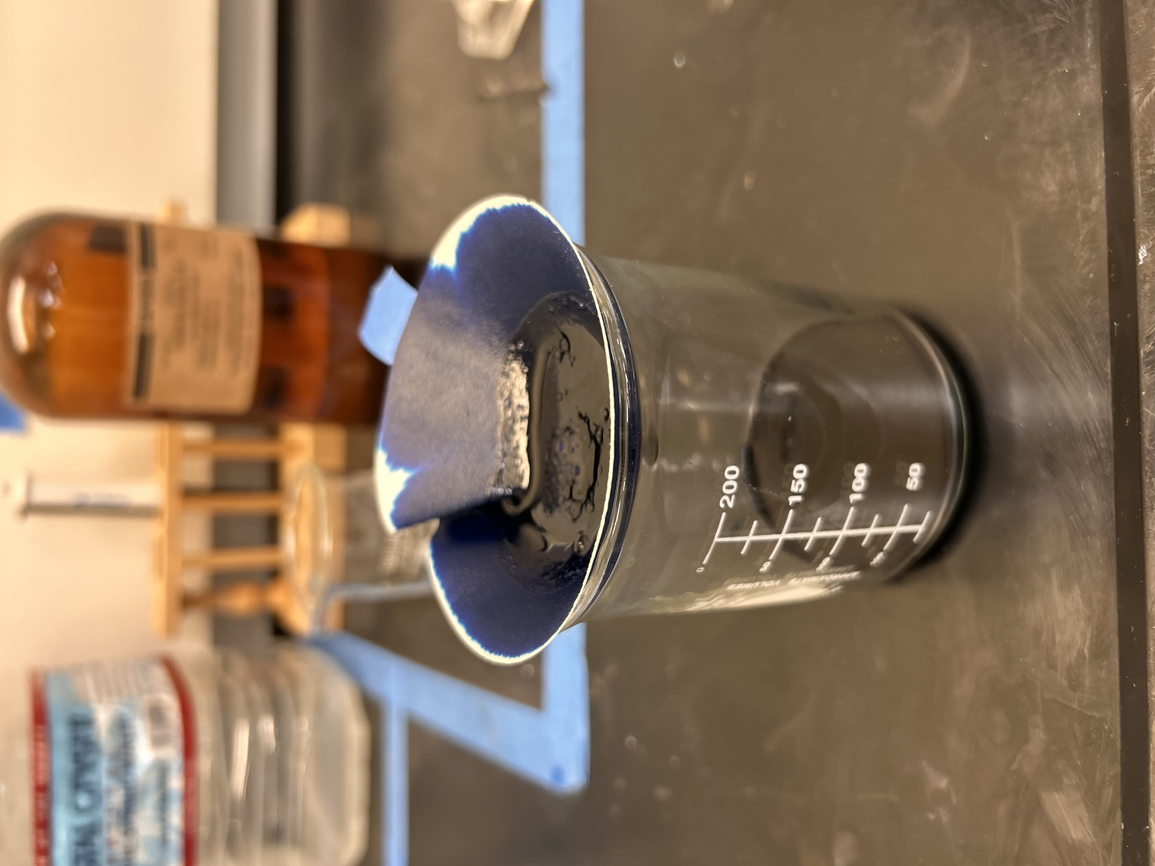 Griffin Blue pigment being prepared in a laboratory beaker using filter material